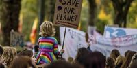 A young climate activist holds a placard during a protest march on Youth Day at the COP26 climate talks in Glasgow, Scotland on Friday, 5 November 2021. (Photo: Jonne Roriz / Bloomberg via Getty Images)
