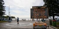 A sign warns of a Beach closure as unkown debris washed up on Coogee Beach in Sydney, Australia, 16 October 2024. Coogee Beach in Sydney’s east closed following the discovery of mysterious, black, ball-shaped debris.  EPA-EFE/STEVEN MARKHAM  AUSTRALIA AND NEW ZEALAND OUT