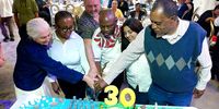 Founder members or associates of the South Durban Community Environmental Alliance (SDCEA) slice up a birthday cake at the alliance’s 30th anniversary celebration in Durban on November 15. They are (from left) Angela Andrews, Thuli Makhama, Rory O’Connor, S‘bu Zikode,  Verushka Memduff and SDCEA coordinator Desmond D’Sa. (Photo: Tony Carnie)