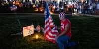 A man who identifies himself as Bubba knees with a flag next to a memorial space during a Charlie Kirk vigil at Burlington Commons on September 17, 2025 in Burlington, Kentucky. Kirk, the CEO and co-founder of Turning Point USA, was shot and killed on September 10 while speaking at an event for his "American Comeback Tour" at Utah Valley University. (Photo by Jon Cherry/Getty Images)