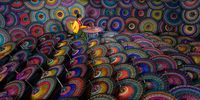 "Colourful Life". A young woman in an umbrella workshop, making a traditional Burmese parasol in Mandalay, Myanmar – handmade using bamboo and cotton. © Saravut Whanset, Thailand, Shortlist, Open, Travel, 2022 Sony World Photography Awards