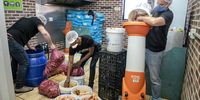 From left,  Michael Eads, Ricardo Mabuku and Woodstock Brewery owner André Viljoen feed vegetables into the shoot that fills the boiler at the Woodstock Brewery, Cape Town. (Photo: Zeke du Plessis)