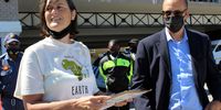 Francesca de Gasparis, executive director of Safcei, hands over protesters' demands to Peter Bester, programme manager for nuclear power plants, at a protest outside the NNR office in Table View, Cape Town, on 17 February 2022. (Photo: Tamsin Metelerkamp)