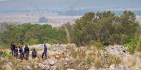 Police officers stand watchfully at the VMR mine in Stilfontein, observing as people try to aid illegal miners trapped underground. (Photo: Supplied)