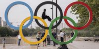 Visitors pose for photos on the Olympic rings sculpture on Bastille Square in central Paris, France, on Wednesday, July 24, 2024. After the Olympics, Air France  which is one of the event sponsors  expects travel to and from Paris to return to normal, with the summer games likely to spark renewed interest in the destination, it said. Photographer: Nathan Laine/Bloomberg via Getty Images