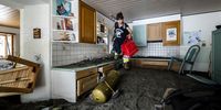 Irina Biadici climbs over the rubble-filled kitchen after packing hard disks and documents into a bag as she returned to the family's house for the first time after the storm to save the most important things, in Piano di Peccia, in the Maggia Valley, southern Switzerland, 03 July 2024 (issued 04 July 2024). During the storm on Saturday 29 June night, Elio Biadici and his wife Christine were able to escape from their house via a small footbridge over the nearby river. A short time later, the bridge was swept away by the river's floodwaters. Severe storms and torrential rain over the last weekend left five people dead in Switzerland's Val Maggia and its side valleys in Ticino.  EPA-EFE/MICHAEL BUHOLZER  ATTENTION: This Image is part of a PHOTO SET