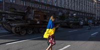 epa10136259 A woman with Ukrainian flag walks past Russian armored military vehicles that were captured in fights by the Ukrainian army, displayed in Khreshchatyk street on Independence Day, in downtown Kyiv, Ukraine, 24 August 2022. Ukrainians mark the 31st anniversary of Ukraine's independence from the Soviet Union in 1991, as the Russian invasion continues six months since its beginning. Russian troops on 24 February entered Ukrainian territory, starting the conflict that has provoked destruction and a humanitarian crisis.  EPA-EFE/ROMAN PILIPEY