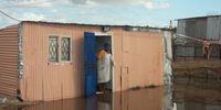 Avuziwe Mpiti stands with her one-year-old child on her back at the entrance to her shack. (Photo: Vincent Lali)