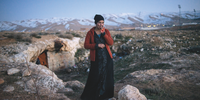 Dalal, 21, a Syrian refugee from the Damascus suburbs, stands in front of the cave she and her family have been staying in since crossing into Lebanon roughly a week prior, in Baalbak, Lebanon. 22 January 2013. (Credit: Lynsey Addario for The New York Times)