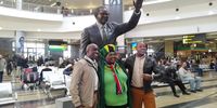Coach of the U/23 Men's Football Team, David Notoane, poses with fans under the statue of Oliver Tambo at OR Tambo International Airport. Photo by Yanga Sibembe
