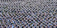 People take part in a yoga exercise at My Dinh National Stadium in Hanoi, Vietnam, 12 August 2023. Some 5,000 yoga participants joined in a yoga event at the stadium on 12 August, which is expected to set a Vietnamese Guinness record.  EPA-EFE/LUONG THAI LINH