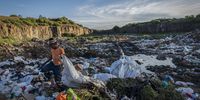 A rubbish collector walks through a dumpsite in Frankfort. The municipality applied to have the dumpsite extended but their application was denied by the Department of Environmental Affairs.  An appeal was made which prompted an online petition because of contamination and health risks that the dumpsite poses which is situated alongside the Wilge River.<br>Daily Maverick / Shiraaz Mohamed