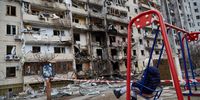 KYIV, UKRAINE - FEBRUARY 25: A child on a swing outside a residential building damaged by a missile on February 25, 2022 in Kyiv, Ukraine. Yesterday, Russia began a large-scale attack on Ukraine, with Russian troops invading the country from the north, east and south, accompanied by air strikes and shelling. The Ukrainian president said that at least 137 Ukrainian soldiers were killed by the end of the first day.  (Photo by Pierre Crom/Getty Images)