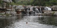 Hikers cool off next to one of nearly 20 waterfalls at Mkambati.