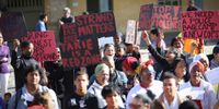 Community activists hold up placards at the Castle of Good Hope prior to their march to Parliament to commemorate victims of gang violence on the Cape Flats. The Alcardo Andrews Foundation: Moms Move for Justice organised the march which included around 300 people including mothers and community members, 1 August 2019. Photo: Leila Dougan