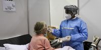 A volunteer-enrolled nurse, Precious Ntozakhe, helps to feed a patient at the Nasrec Field Hospital. The care requirements for patients at the hospital are constant and varied and require all nursing skill levels.<br>(Photo: Chris Collingridge)
