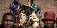 Mineworkers sit on the koppie before the ceremony. (Photo: Shiraaz Mohamed)