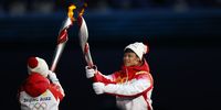 epa09727894 Torch bearers transfer the flame between torches during the Opening Ceremony for the Beijing 2022 Olympic Games at the National Stadium, also known as Bird's Nest, in Beijing China, 04 February 2022.  EPA-EFE/Alex Plavevski