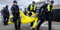 Activists from Extinction Rebellion are led away by police during the 'Stop cruise ship pollution!' action during the arrival of cruise ship MSC Virtuosa at IJmuiden port, the Netherlands, 21 October 2024. According to the Extinction Rebellion, these ships cause a massive flow of tourists that affects local ecosystems, not just environmentally, but also economically for communities that depend on healthy oceans.  EPA-EFE/RAMON VAN FLYMEN