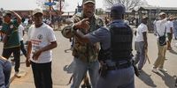 A South African Police Service (SAPS) officer removes members of Operation Dudula during a protest against undocumented migrants after a scuffle with members of the Economic Freedom Fighters outside Kalafong hospital in Atteridgeville, west of Pretoria, on 1 September 1, 2022. (Photo by Phill Magakoe / AFP)