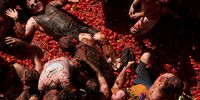 BUNOL, SPAIN - AUGUST 31: Revellers covered in tomato pulp while participating the annual Tomatina festival on August 31, 2022 in Bunol, Spain. The world's largest food fight festival, La Tomatina, consists of throwing overripe and low-quality tomatoes at each other. (Photo by Manuel Queimadelos Alonso/Getty Images)