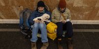 KYIV, UKRAINE - FEBRUARY 24: People shelter with their dog in a subway station before a curfew comes into effect on February 24, 2022 in Kyiv, Ukraine. Overnight, Russia began a large-scale attack on Ukraine, with explosions reported in multiple cities and far outside the restive eastern regions held by Russian-backed rebels. (Photo by Chris McGrath/Getty Images)