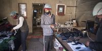 Grace Mabuya, right, Austin Mashale, centre, and Paulos Komane, left, in Shikweni's garage which acts as their factory. (Photo: Shiraaz Mohamed)