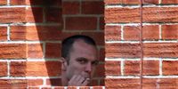 Lance Corporal Joe Glenton smokes a cigarette as he looks out from a window at the Bulford Military Court Centre on 3 August 2009 near Salisbury, England. (Photo: Matt Cardy/Getty Images)