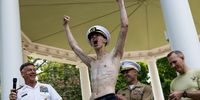 Fourth Class Midshipman Chris Paris, 20, of the 28th Company, cheers alongside Naval Academy Vice Admiral Sean Buck (L) after placing the upperclassman's hat on top of the Herndon Monument, during the annual Herndon Monument Climb at the U.S. Naval Academy on May 17, 2023 in Annapolis, Maryland. In just over two and a half hours, members of the 2026 midshipmen's class worked  to scale the 21-foot greased monument and replace a “dixie cup” hat with the upperclassmen's hat, signifying the end of their “plebe” year. (Photo by Anna Moneymaker/Getty Images)