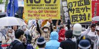 Protesters carry placards as they gather near the A-bomb Dome at the Hiroshima Peace Memorial Park, as part of a demonstration against the summit, ahead of the G7 Hiroshima Summit in Hiroshima, Japan, 18 May 2023. The G7 Hiroshima Summit will be held from 19 to 21 May 2023.  EPA-EFE/KIMIMASA MAYAMA