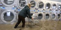PAJARO, CALIFORNIA - MARCH 14: Pamela Cerruti pushes a cart filled with a bag of coins out of the flooded Pajaro Coin Laundry on March 14, 2023 in Pajaro, California. Northern California has been hit by another atmospheric river that has brought heavy rains and flooding throughout the region. The town has been inundated with floodwaters since Saturday after a levee was breached along the Pajaro River. (Photo by Justin Sullivan/Getty Images)