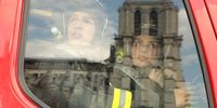 Firefighters look out of their truck at the Notre-Dame, reflected in their vehicle window. Production still from 'Notre-Dame On Fire'. Image: courtesy of Universal Studios