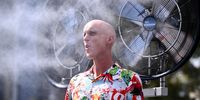 A guests cools off with mister fans as play is suspended on the outside courts due to extreme heat conditions on day 10 of the 2026 Australian Open tennis tournament at Melbourne Park in Melbourne, Australia, 27 January 2026.  (Photo: EPA / Joel Carrett)