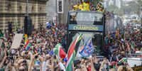 Springbok captain Siya Kolisi, centre, holds the Webb Ellis Cup as supporters cheer the team.  (Photo: EPA-EFE / Nic Bothma)