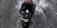 A man rides a motorcycle during rainfall, after Cyclone Dana hit the state of West Bengal, in Kolkata, India, 25 October 2024. Severe cyclonic storm 'Dana' is expected to impact mostly the eastern Indian state Odisha, and coastal districts of West Bengal, according to India Meteorological Department (IMD). More than 500,000 people have been relocated to cyclone shelters in Odisha, according to local authorities.  EPA-EFE/PIYAL ADHIKARY