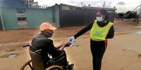 Local Amadiba Crisis Committee Team members in Bekela Village preparing to distribute sanitiser, masks and gloves. An ACC team member helps a man to sanitise his hands. ( Photo: Supplied)