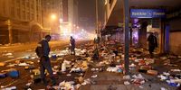 Police officers look at the remains of looted shops during protests in downtown Durban on 12 July 2021. (Photo: EPA-EFE / STR)