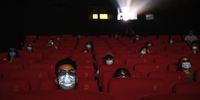 People wear protective masks as they watch a movie in 3D at a theatre on the first day they were permitted to open on 24 July 2020 in Beijing, China. Cinemas in China's capital city re-opened after being closed for six months due to the Covid-19 pandemic. (Photo: Kevin Frayer / Getty Images)