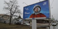 epa09120491 Russian people pass by a poster with a portrait of the first USSR cosmonaut Yuri Gagarin, that reads: 'We are the first' in St. Petersburg, Russia, 07 April 2021. Russia marks the 60th anniversary of the first human spaceflight on April 12.  EPA-EFE/ANATOLY MALTSEV