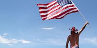 DAYTONA BEACH, FL - JULY 07:  A fan waves an American Flag in the infield prior to the Monster Energy NASCAR Cup Series Coke Zero Sugar 400 at Daytona International Speedway on July 7, 2018 in Daytona Beach, Florida.  (Photo by Sean Gardner/Getty Images)