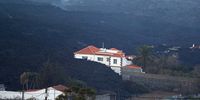 epa09563628 A view of a house sourrounded by lava expelled by Cumbre Vieja volcano in La Palma, Canary Islands, Spain, 04 November 2021. The high concentration of sulfur dioxide (SO2) and a big cloud of ashes have worsen the air quality in the island. Authorities have asked people not to leave their homes unless necessary, wearing masks the whole time.  EPA-EFE/Elvira Urquijo A.