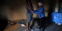 Mentor mother Nosizwe Peter weighs one of Aphiwe Tyhontsi’s twin daughters, both of whom were born underweight. (Photo: Oupa Nkosi)