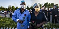 Medical workers hold roses as they pay tribute to the fallen five.<br>Photo / Shiraaz Mohamed