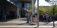Standard Bank private security observe (left), while climate activists speak to SAPS officials on the other side of the barrier (right) at the Standard Bank Rosebank offices in Johannesburg. (Photo: Julia Evans)