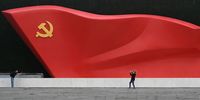 BEIJING, CHINA - JUNE 25: Journalists take photos as they stand on a monument with a large Communist Party flag outside the newly built Museum of the Communist Party of China on June 25, 2021 in Beijing, China. China will mark the 100th anniversary of the founding of the Communist Party on July 1st.  (Photo by Kevin Frayer/Getty Images)