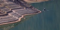 OROVILLE, CALIFORNIA - JUNE 01: Water lines are visible on the steep banks of Lake Oroville as a fisherman floats by on June 01, 2021 in Oroville, California. As the extreme drought takes hold in California, water levels at reservoirs are falling fast. Lake Oroville is currently at 38 percent of capacity. According to the U.S. Drought Monitor, 16% of California is in exceptional drought, the most severe level of dryness. (Photo by Justin Sullivan/Getty Images)