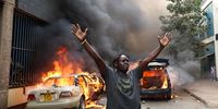 A man gestures next to vehicles set alight by protesters in the central business district of Nairobi, Kenya, 12 June 2025. Police used tear gas on protesters demanding the resignation of Deputy Inspector General Eliud Lagat following the death of Kenyan blogger Albert Ojwang while in police custody. Ojwang, 31, was arrested along with several others following a complaint filed by the deputy inspector-general of police, Eliud Kipkoech Lagat, over posts on social media accusing him of corruption.  EPA-EFE/DANIEL IRUNGU