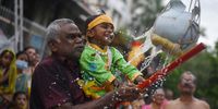 epa10127608 A Hindu devotee along with a child breaks a pot of milk as part of a ritual during the celebrations on the eve of the Krishna Janmashtami festival in Chennai, India, 18 August 2022. The festival celebrates the birth of the Hindu god Lord Krishna, one of the most popular gods in Hinduism.  EPA-EFE/IDREES MOHAMMED