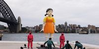SYDNEY, AUSTRALIA - OCTOBER 29: A replica animated doll from the series "Squid Game" is seen on October 29, 2021 in Sydney, Australia. The replica animated doll from the Netflix series Squid Game has been installed at Sydney Harbour for Halloween. The doll, which is 4.5 metres tall and weighs three tonnes, can turn its head and chants "red light, green light." Sydneysiders are invited to play the children's game made popular by the television show. (Photo by Brook Mitchell/Getty Images)