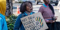 Activists protest outside TotalEnergies’ head office in Rosebank, Johannesburg, against the company’s fossil fuel operations, 5 May 2025. (Photo: Julia Evans)